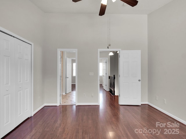 unfurnished bedroom with a closet, wood finished floors, and baseboards