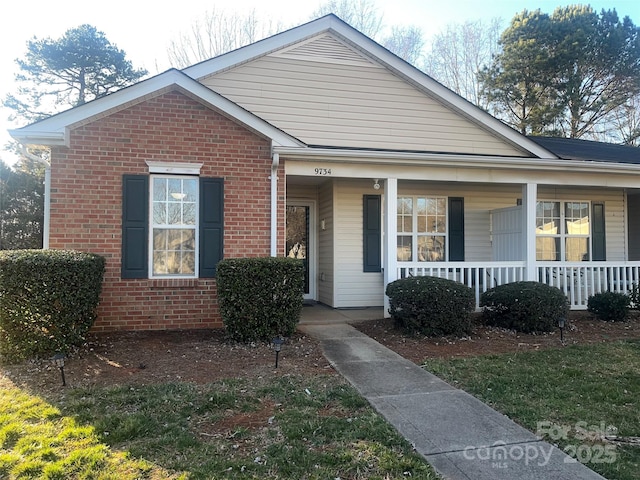 view of front of house featuring covered porch and brick siding