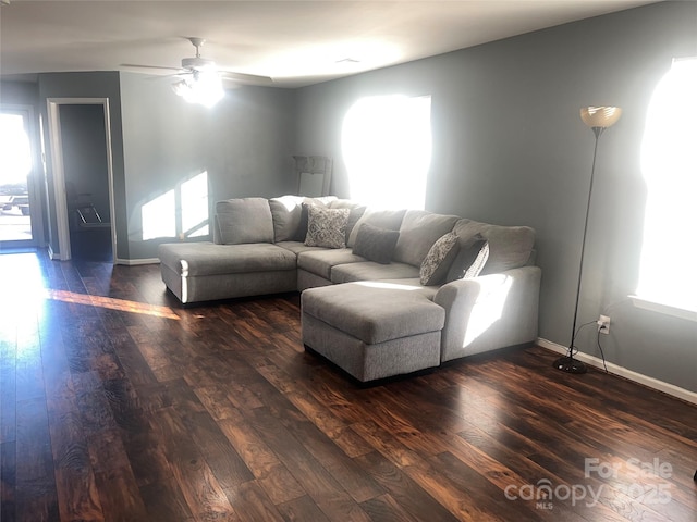 living room featuring dark wood finished floors, a wealth of natural light, and baseboards