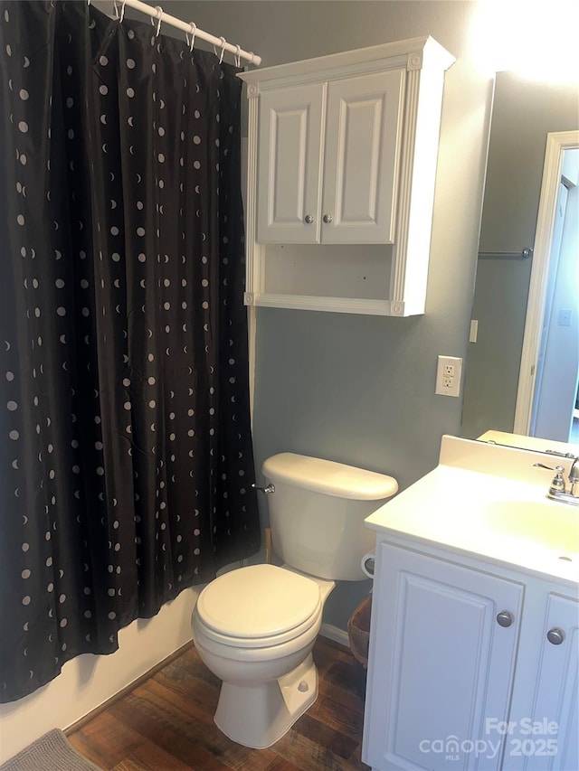 bathroom with toilet, wood finished floors, and vanity