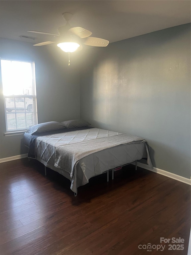 bedroom featuring visible vents, baseboards, and wood finished floors