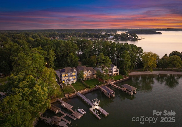 aerial view at dusk featuring a water view