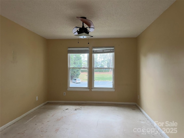 unfurnished room featuring baseboards and a textured ceiling