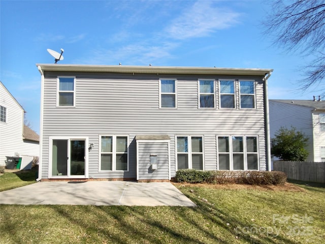 rear view of property featuring a yard, a patio, and fence