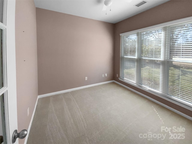 unfurnished room with carpet, visible vents, ceiling fan, and baseboards