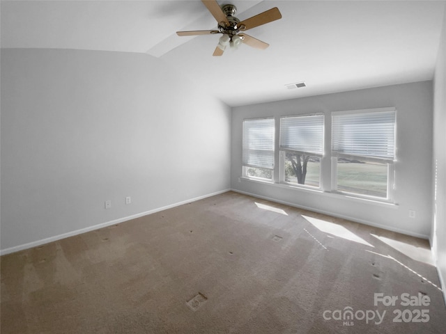 unfurnished room featuring lofted ceiling, ceiling fan, carpet floors, visible vents, and baseboards