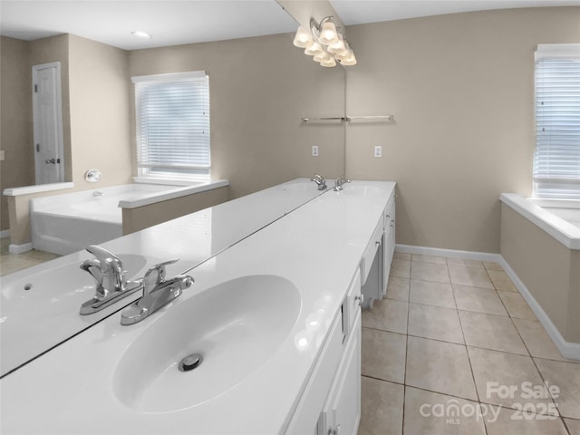 bathroom with tile patterned flooring, a sink, a bath, and baseboards