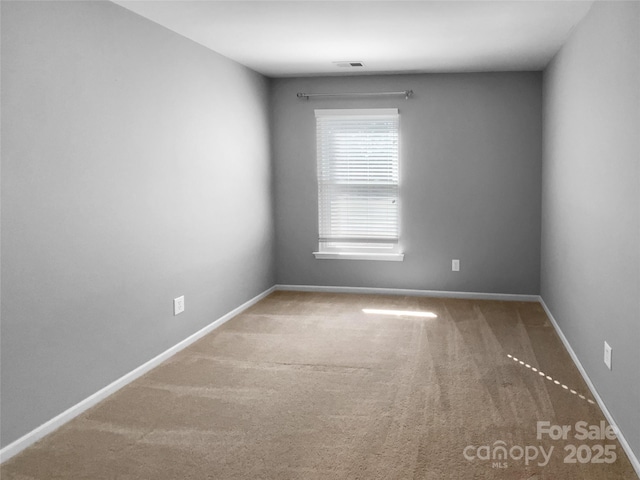 spare room featuring visible vents, baseboards, and carpet flooring