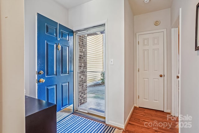 foyer entrance with wood finished floors and baseboards