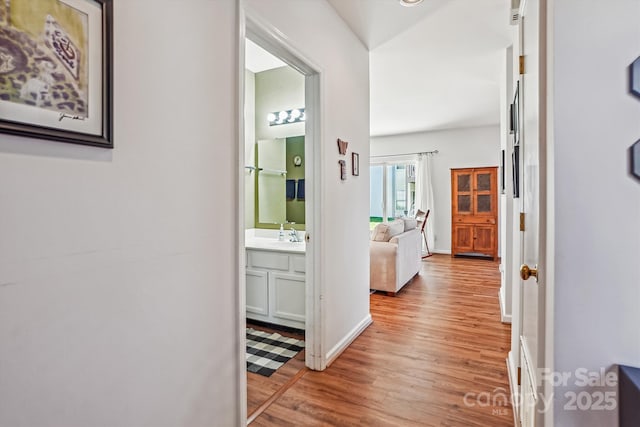 hallway featuring baseboards and wood finished floors