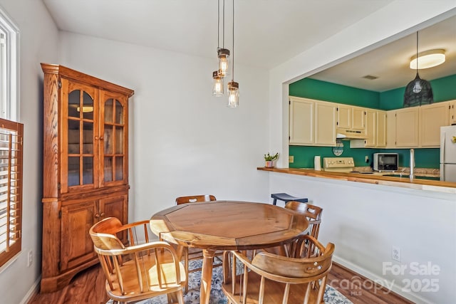 dining space with baseboards, visible vents, and dark wood-style flooring