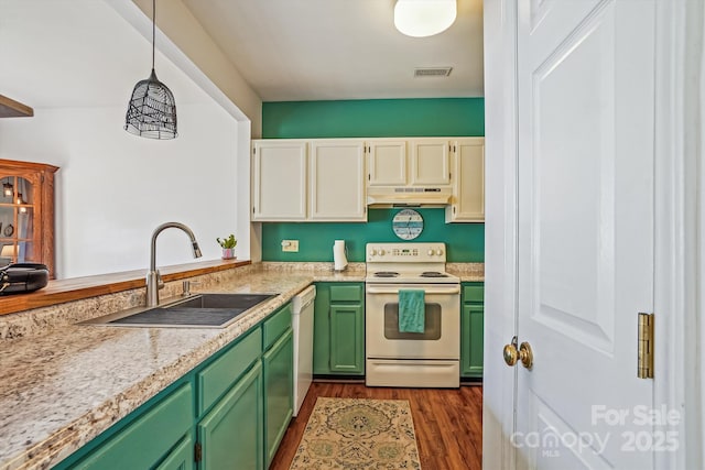 kitchen featuring under cabinet range hood, white appliances, a sink, visible vents, and green cabinetry