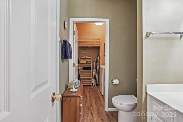 bathroom featuring vanity, toilet, and wood finished floors