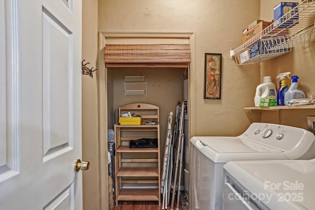 laundry room featuring a textured wall, laundry area, independent washer and dryer, and wood finished floors