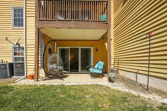 entrance to property with a patio, a balcony, and a lawn