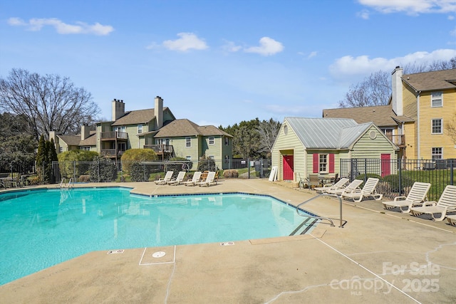 pool featuring a residential view, a patio, and fence