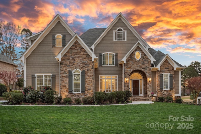 view of front of property with a front yard and stone siding