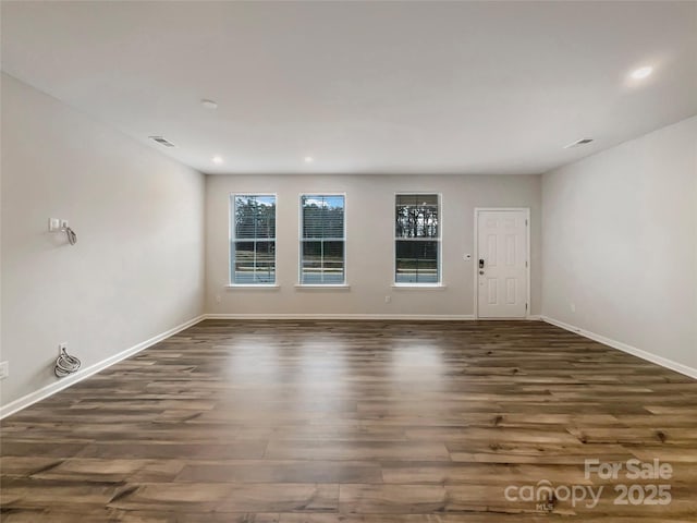 unfurnished room with recessed lighting, wood finished floors, and baseboards