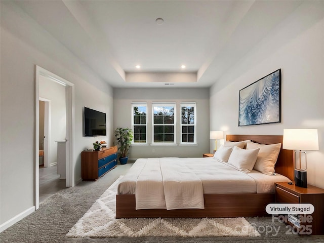 carpeted bedroom featuring baseboards, a tray ceiling, and recessed lighting