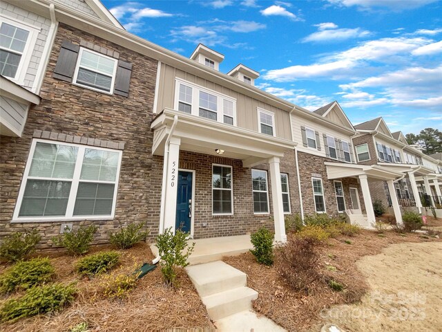 townhome / multi-family property featuring stone siding and board and batten siding