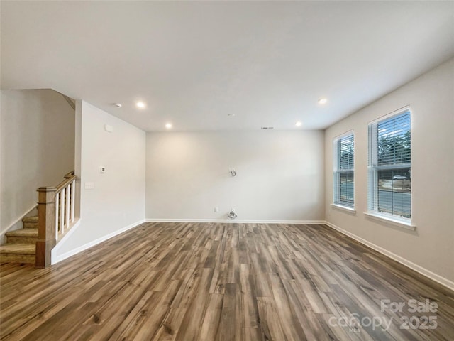 unfurnished room with stairway, recessed lighting, wood finished floors, and baseboards