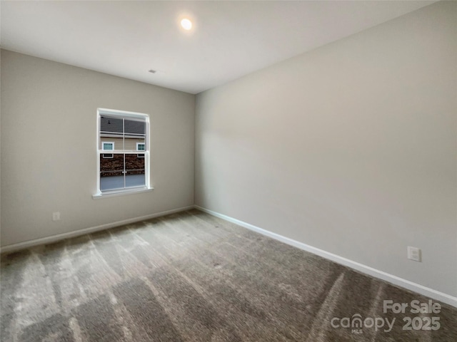 carpeted spare room featuring baseboards