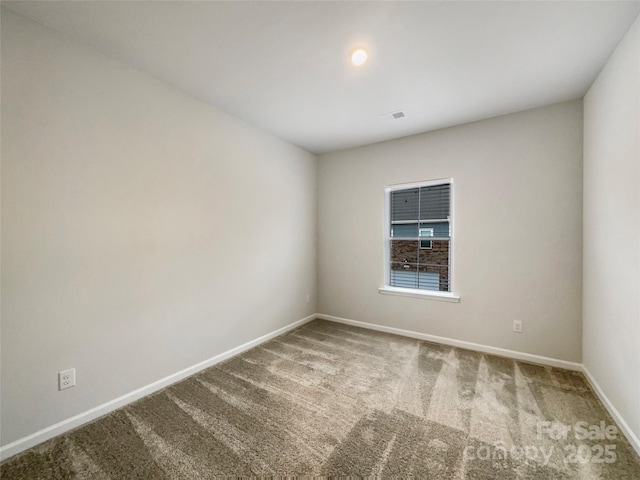 carpeted spare room with visible vents and baseboards