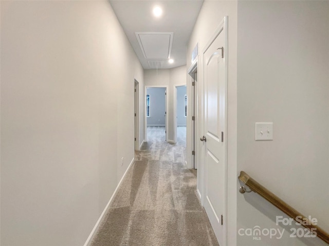 hallway featuring visible vents, carpet flooring, attic access, and baseboards