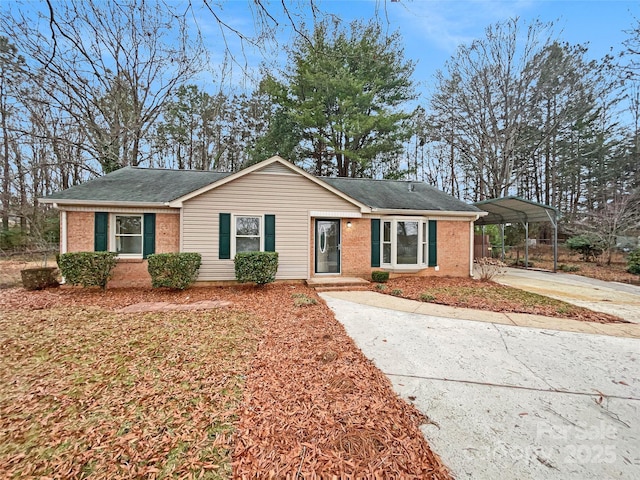 single story home with a detached carport, concrete driveway, and brick siding