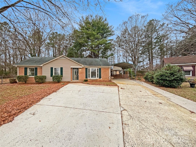 single story home featuring a detached carport, concrete driveway, and brick siding