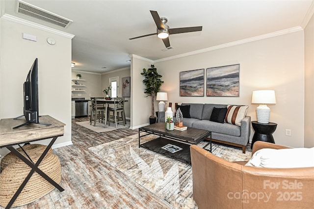 living room featuring visible vents, baseboards, ceiling fan, ornamental molding, and wood finished floors