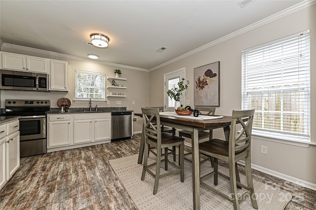 kitchen featuring open shelves, stainless steel appliances, dark wood-style flooring, and crown molding