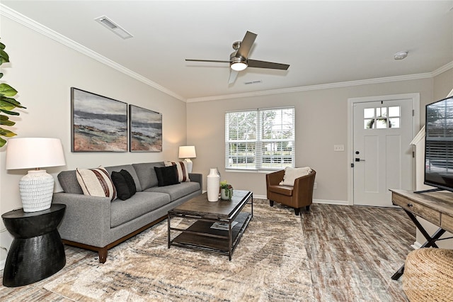 living room featuring visible vents, ceiling fan, crown molding, and baseboards