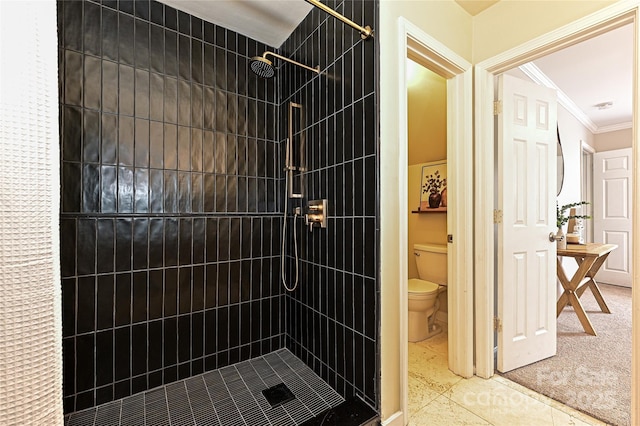 bathroom with a stall shower, toilet, and ornamental molding