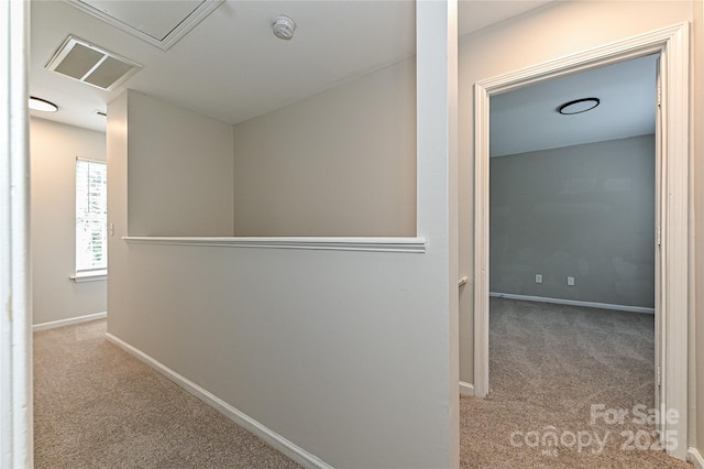 hallway featuring an upstairs landing, carpet, and baseboards