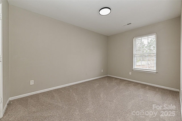 carpeted empty room with visible vents and baseboards