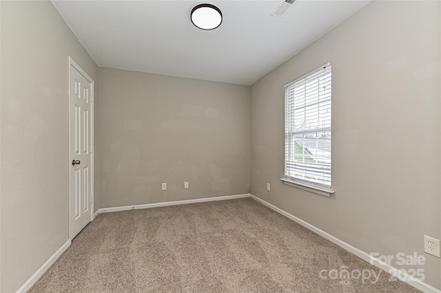 spare room featuring visible vents, baseboards, and light colored carpet