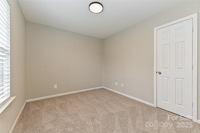 empty room with baseboards and carpet