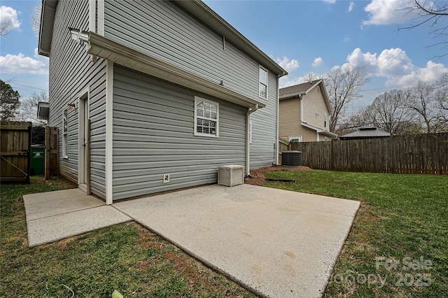 rear view of property with a patio, central air condition unit, a yard, and fence