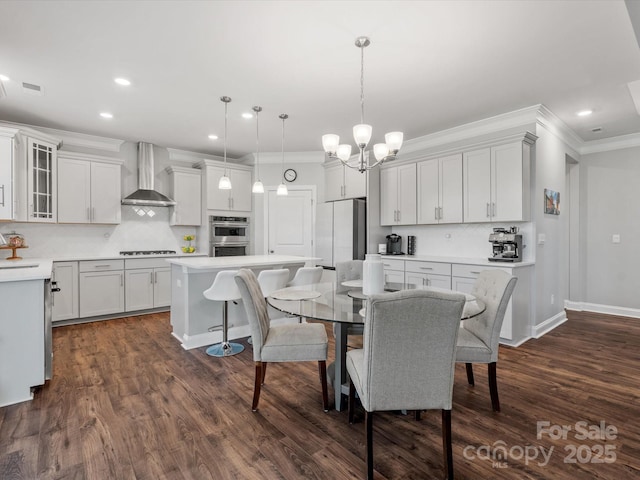 dining room featuring baseboards, dark wood finished floors, ornamental molding, recessed lighting, and an inviting chandelier