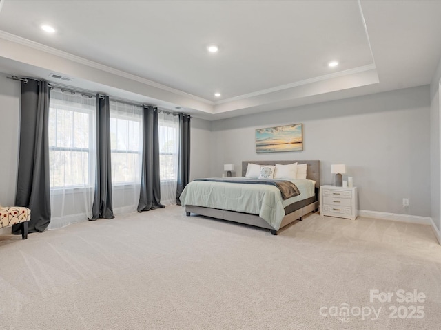 bedroom featuring a tray ceiling, light colored carpet, and crown molding