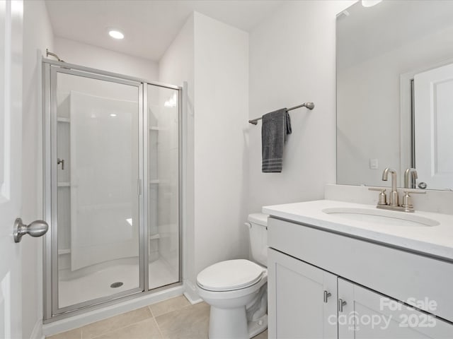 bathroom with vanity, a shower stall, toilet, and tile patterned floors