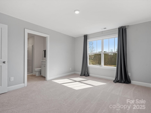 unfurnished bedroom featuring carpet flooring, visible vents, baseboards, and connected bathroom