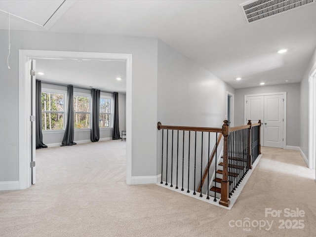 hall with carpet, visible vents, attic access, recessed lighting, and an upstairs landing