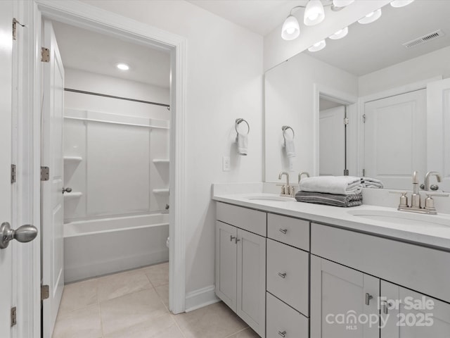 full bath with a sink, visible vents, double vanity, and tile patterned flooring