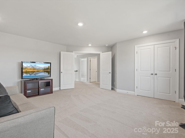 living room with recessed lighting, light colored carpet, and baseboards