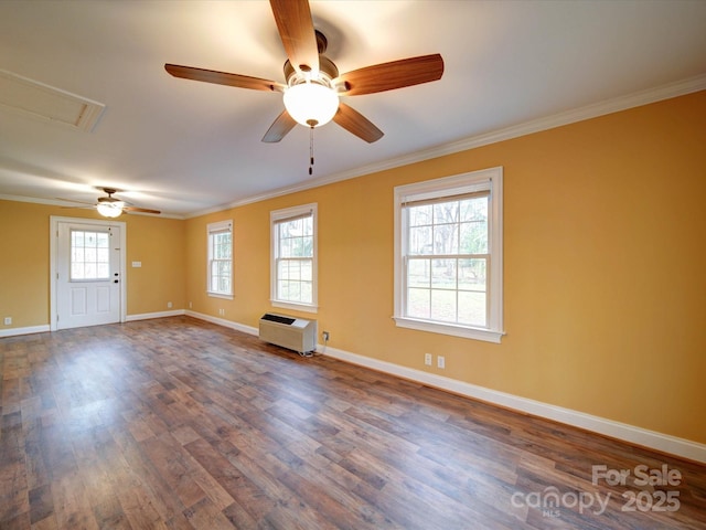 spare room featuring heating unit, a ceiling fan, dark wood-style floors, baseboards, and crown molding