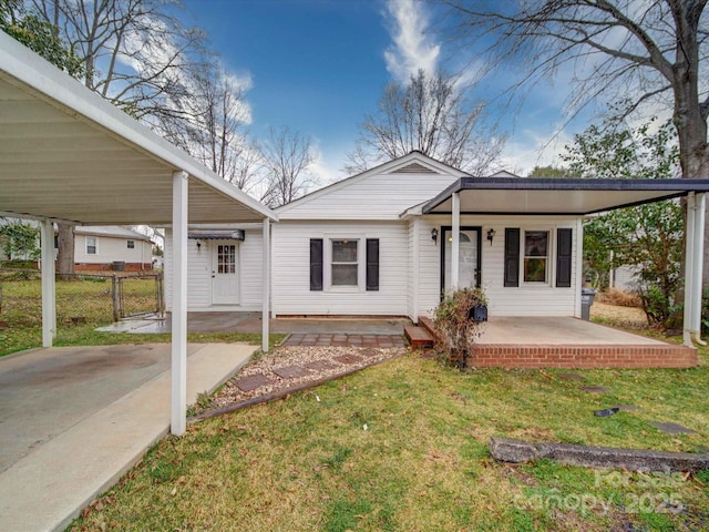 back of house featuring a carport, a yard, fence, and covered porch