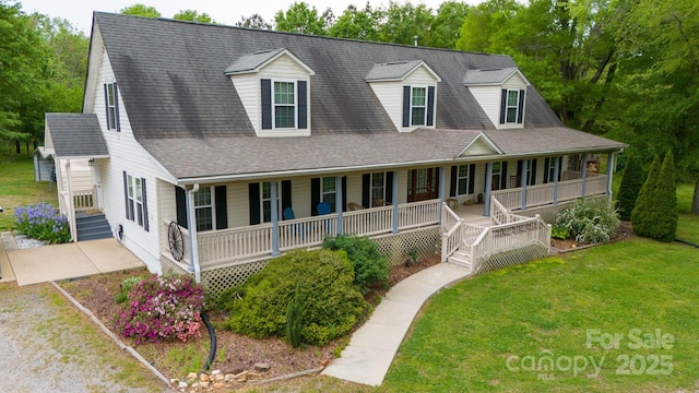 view of front of house with covered porch, driveway, a shingled roof, and a front yard