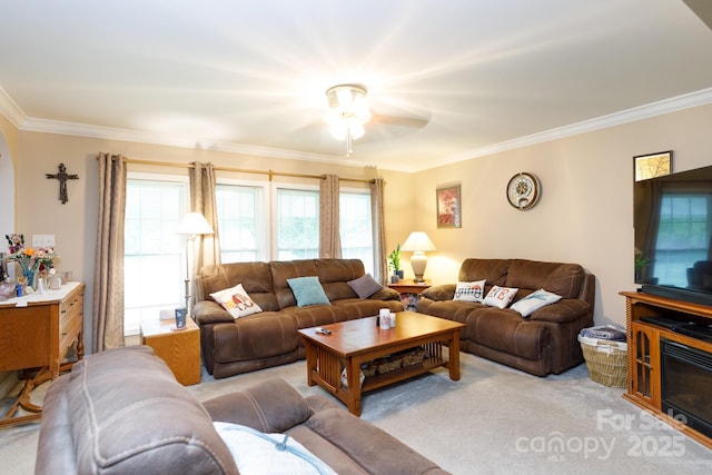 living room with ornamental molding, a ceiling fan, and light colored carpet